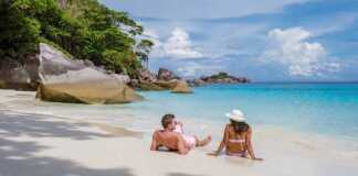 couple sitting on a beach in the similan islands thailand