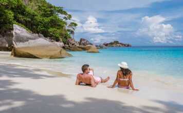 couple sitting on a beach in the similan islands thailand