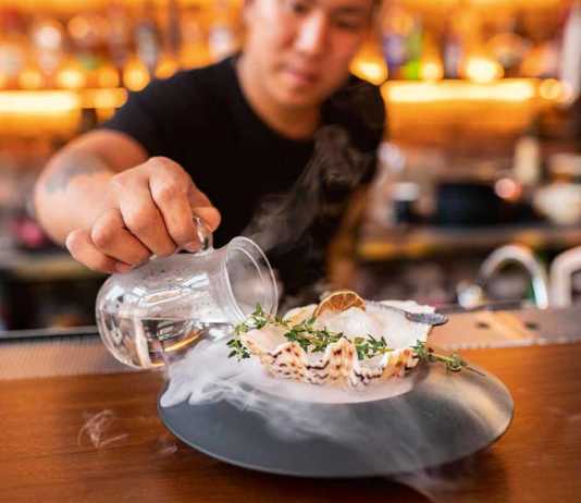 singapore bars Hopscotch bartender pouring liquid into a cocktail served in a shell
