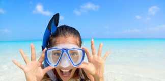girl wearing blue mask and snorkel in the water