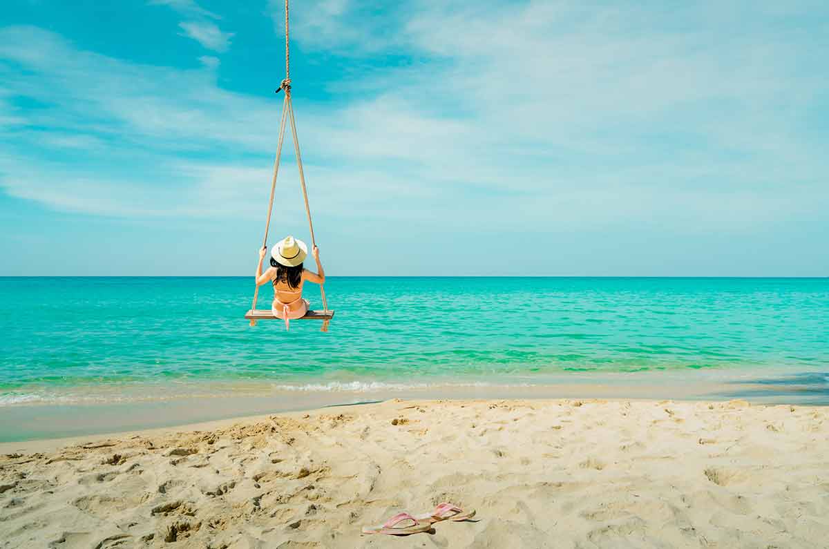 south cambodia beaches Asian woman wear swimwear and hat swing the swings at sand beach