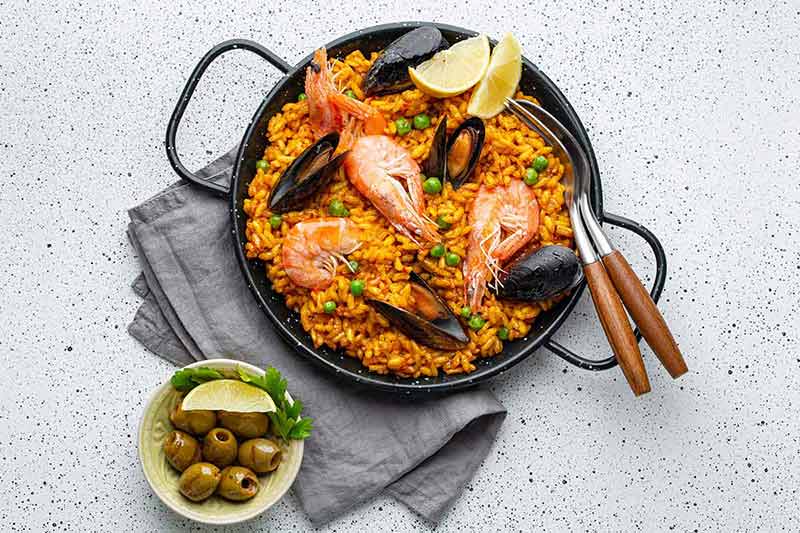 spain christmas traditions Classic seafood paella in traditional pan on white wooden background top view
