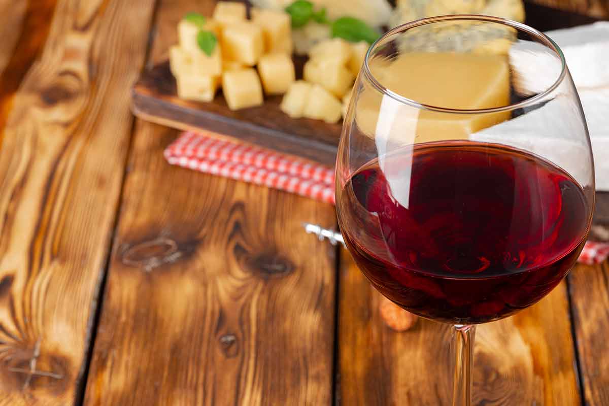 spanish drinks alcoholic red wine glass and cheese blocks on wooden table