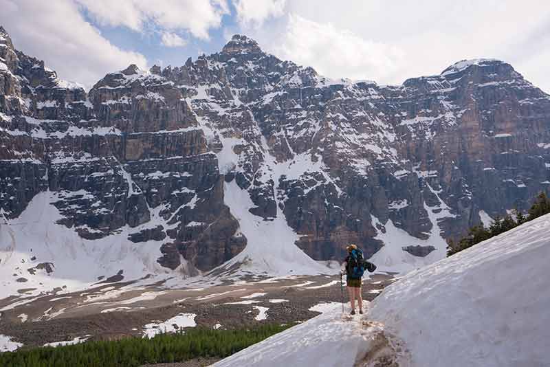 summer in canada hiker in shorts admiring the snow sprinkled mountains in Banff National Park