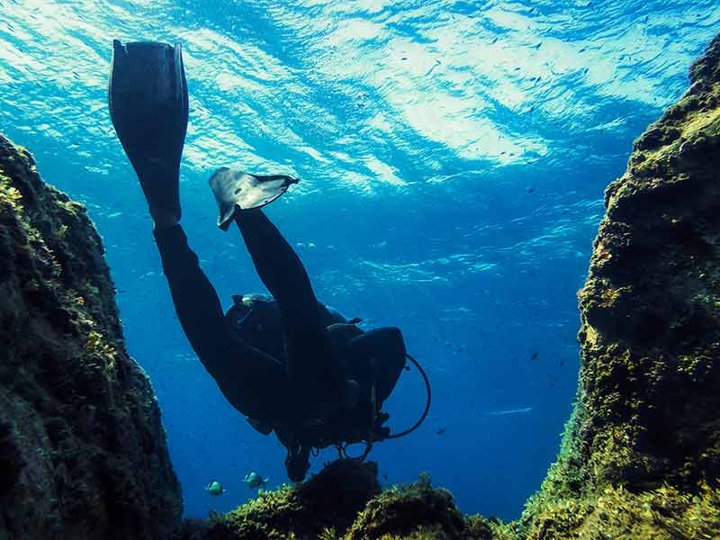 Man Diving Through The Blue Sea