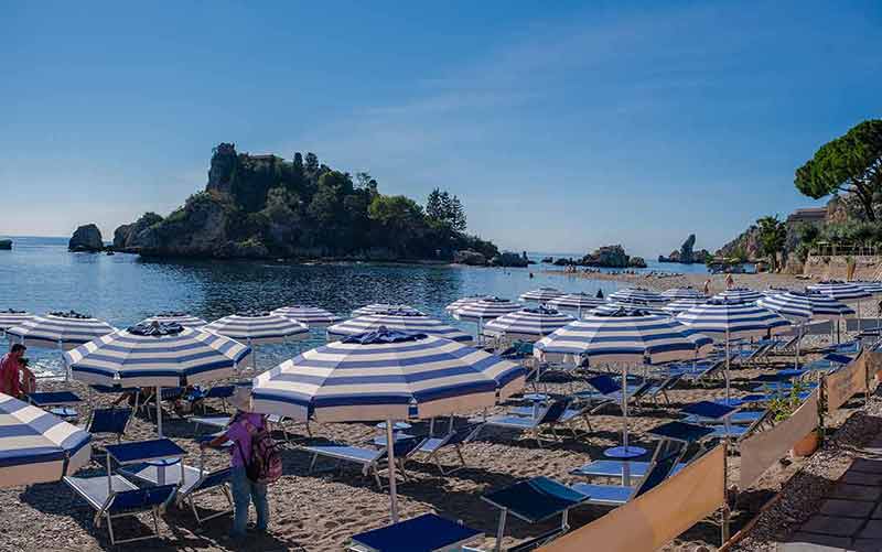 taormina sicily beaches beach umbrellas Aerial view of the island and Isola Bella beach and blue ocean water in Taormina
