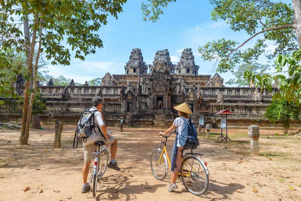 couple on bicycles at the temples of angkor ta keo