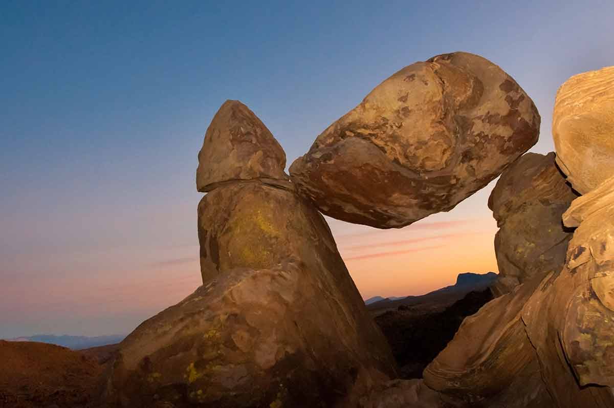 texas national parks map rock balanced precariously between two other boulders at dusk