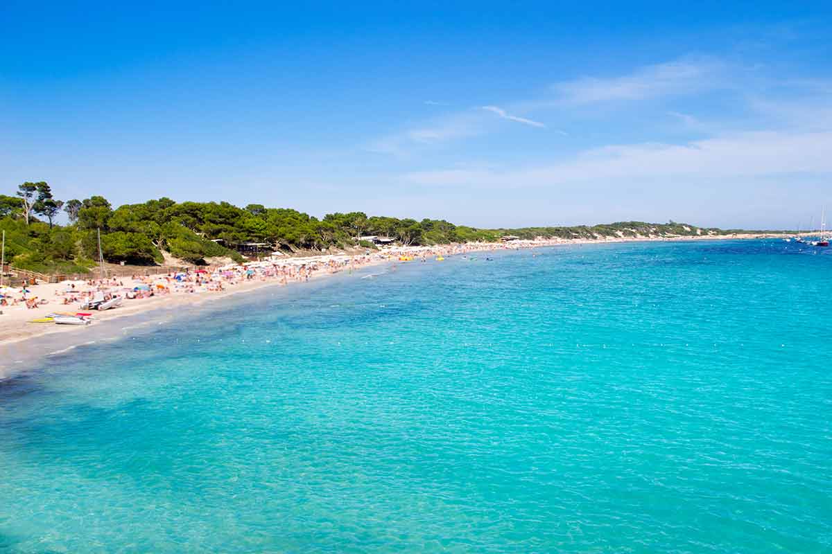 things to do and see in es cana ibiza aquamarine water and hordes of people on the beach