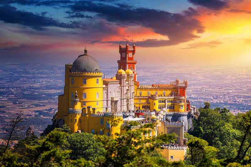 Famous Historic Pena Palace Part Of Cultural Site Of Sintra Against Sunset Sky