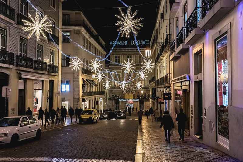 things to do at night in lisbon Christmas lights in a cobblestone street