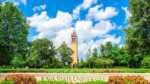 20 things to do in Ames that are better than you think Iowa State University tower, blue sky and green lawns with sign