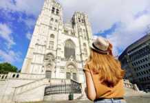 Back View Of Tourist Girl Visiting Brussels Cathedral, Belgium, Europe.
