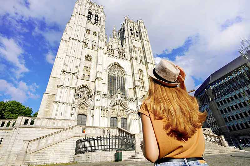 Back View Of Tourist Girl Visiting Brussels Cathedral, Belgium, Europe.