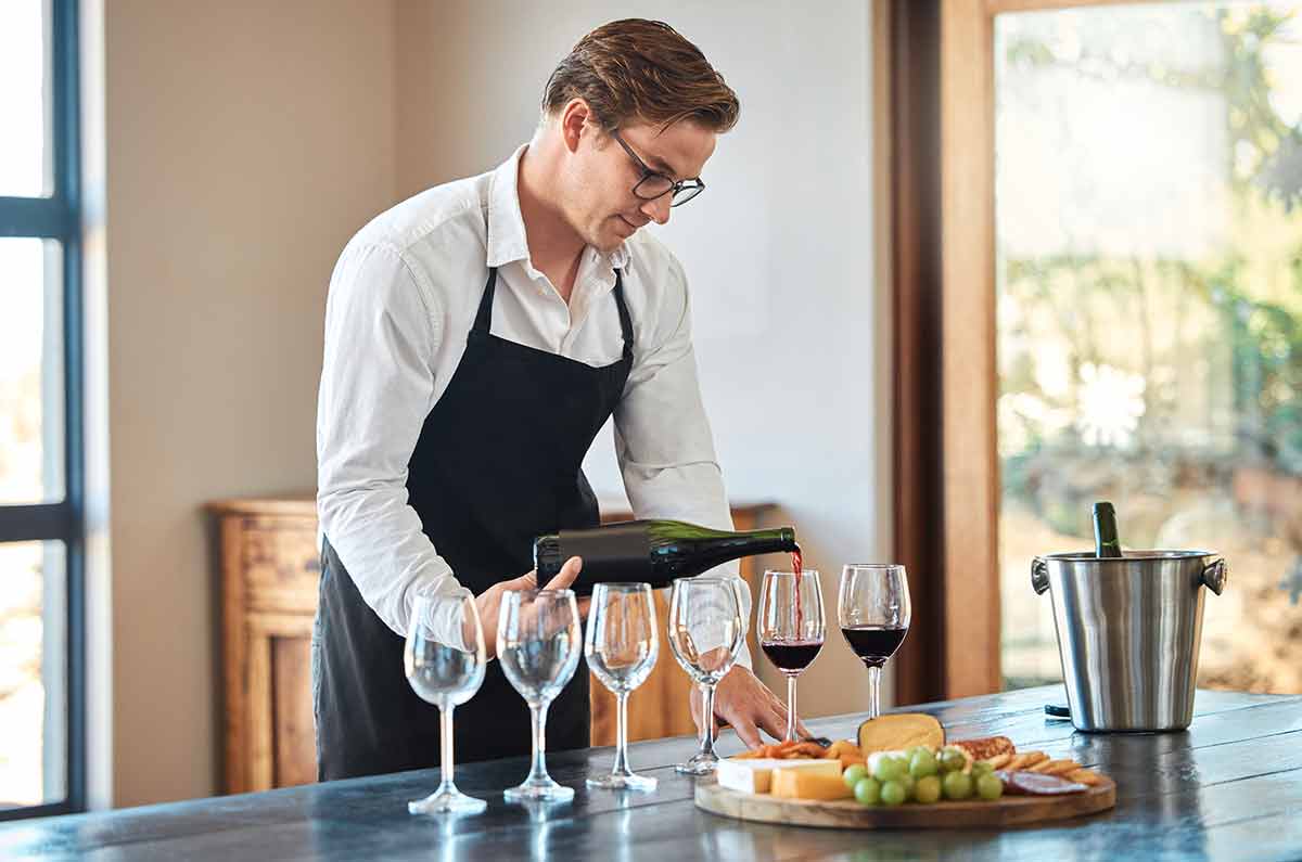 things to do in cary this weekend Waiter, wine tasting, and bartender with glass at fine dining vineyard restaurant in countryside.