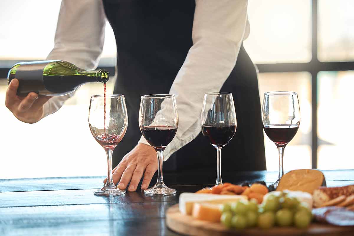 things to do in chesapeake va this weekend Luxury, fine dining and hospitality with a waiter pouring red wine at a restaurant.