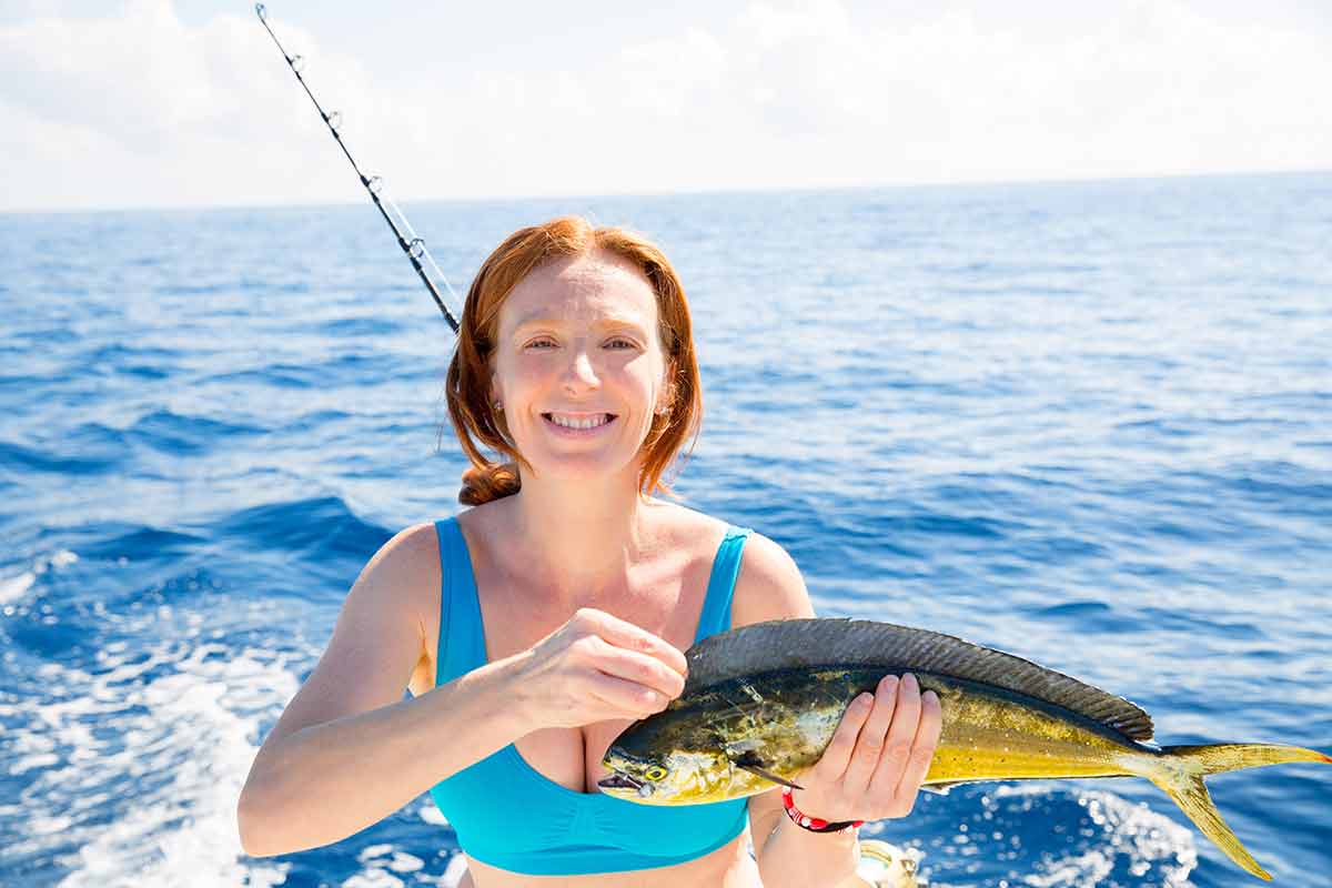 Woman fishing with her catch of Dorado Mahi-Mahi