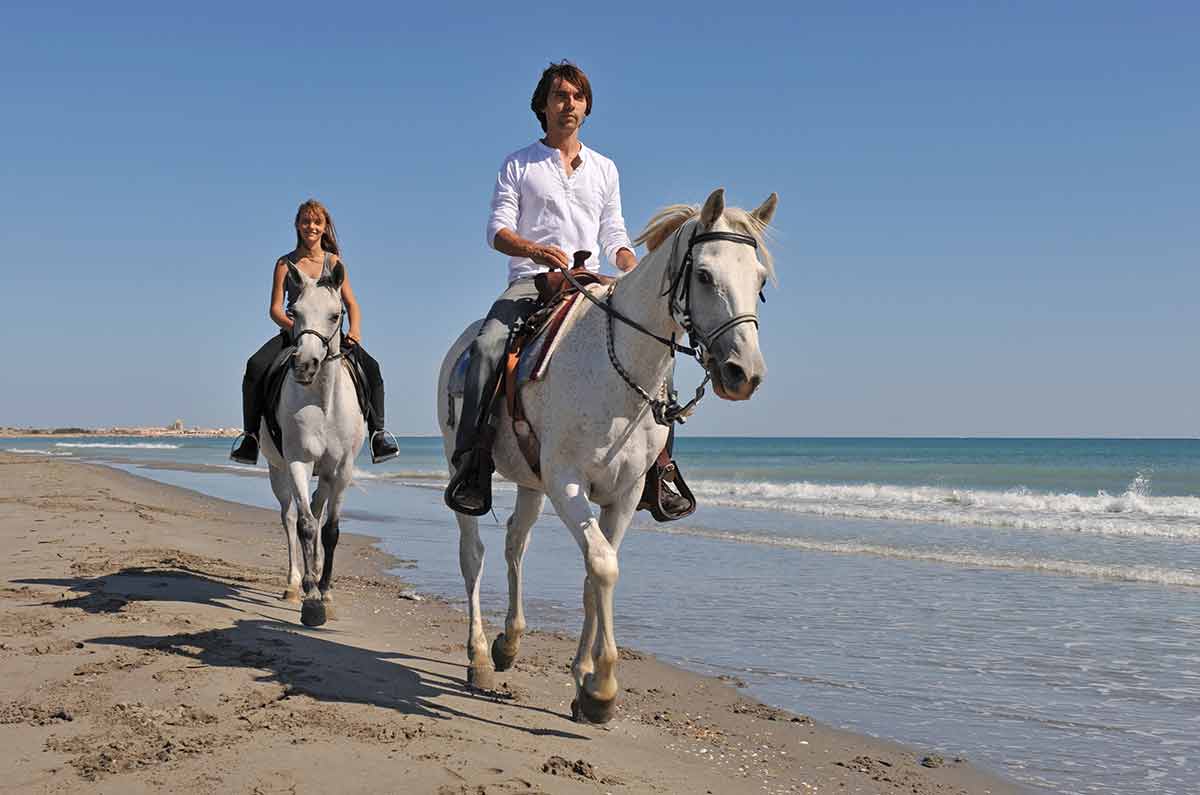things to do in corpus christi for couples Father and daughter are riding with their white horses on the beach.
