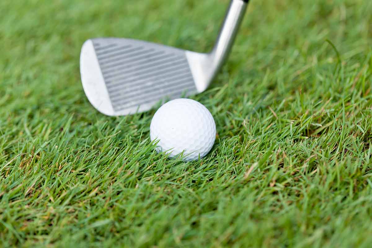 Golf Ball And Iron On Green Grass