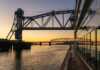 20 Things To Do In Hannibal, Missouri That Channel Mark Twain Vibes sunset as a cruise ship floats beneath the mark twain memorial bridge