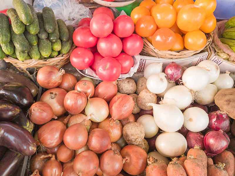 Beautiful, colorful tropical vegetables as background. Fresh and organic vegetables at farmers market. Farmers' food market stall with a variety of organic vegetables.