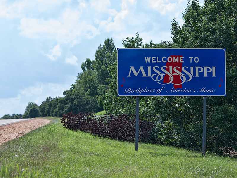 Blue roadsign with the words "Welcome to Mississippi', birthplace of America's music