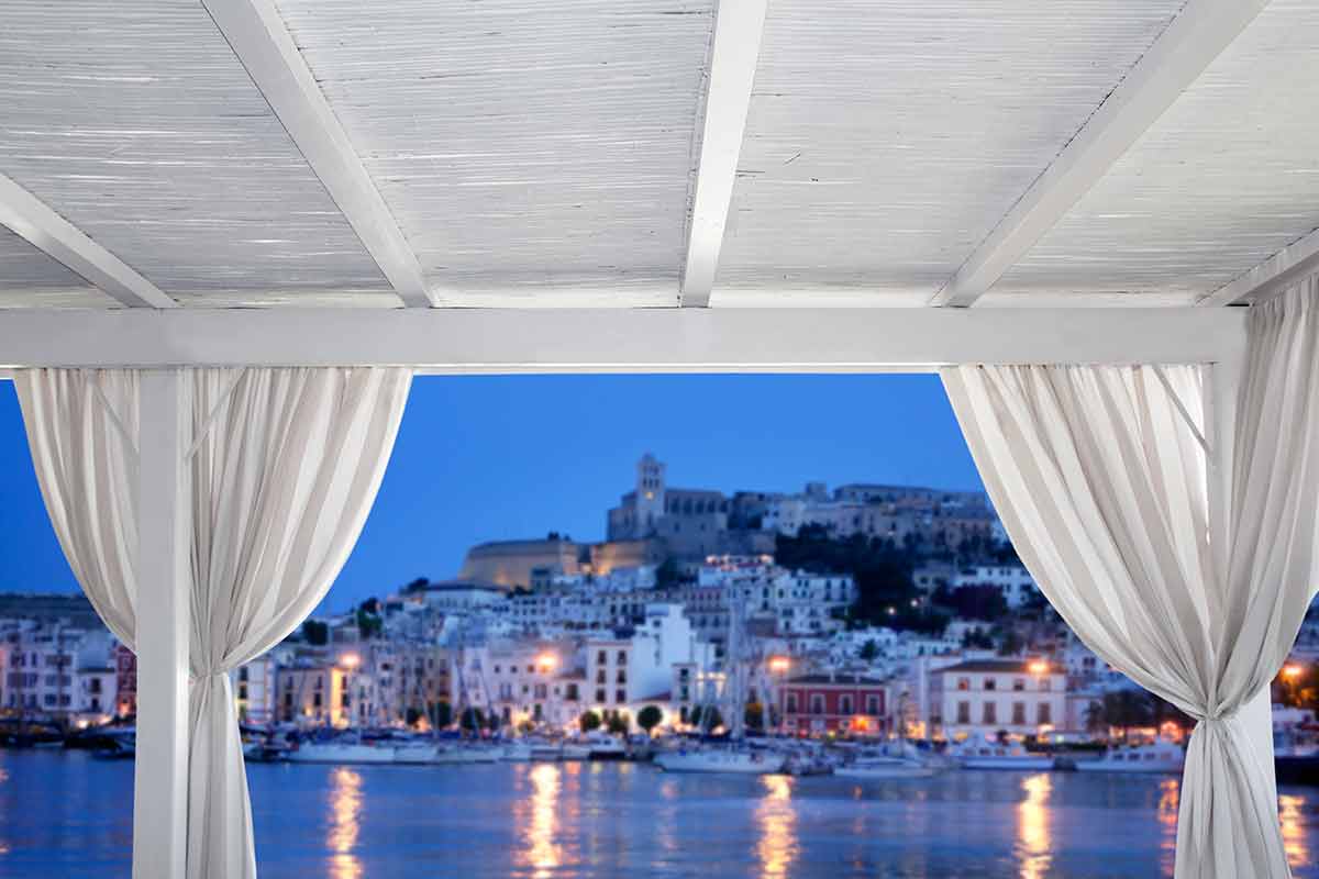 curtains over a beach bed with a view of the old town