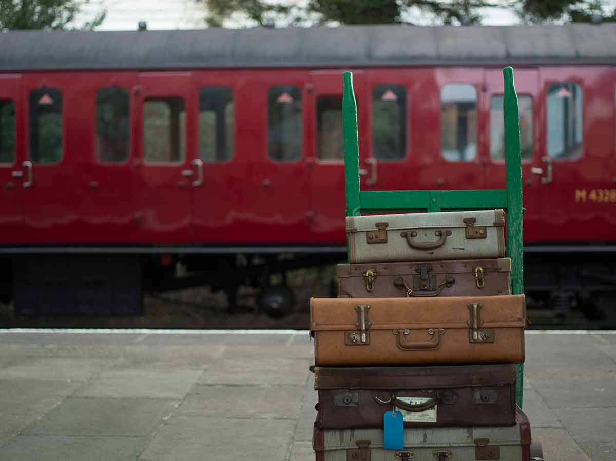 things to do in leicester with kids old suitcases on a train platform with red heritage carriage in the background