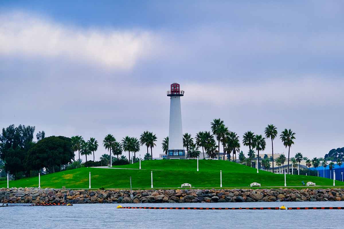 Lighthouse in Long Beach surrounded by palms and green lawn