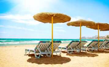beach chairs and thatched umbrellas facing the sea
