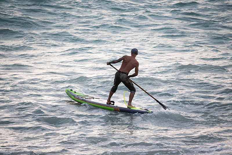 Athletic Wiry Surfer Guy Swims With A Paddle On A Sup Board
