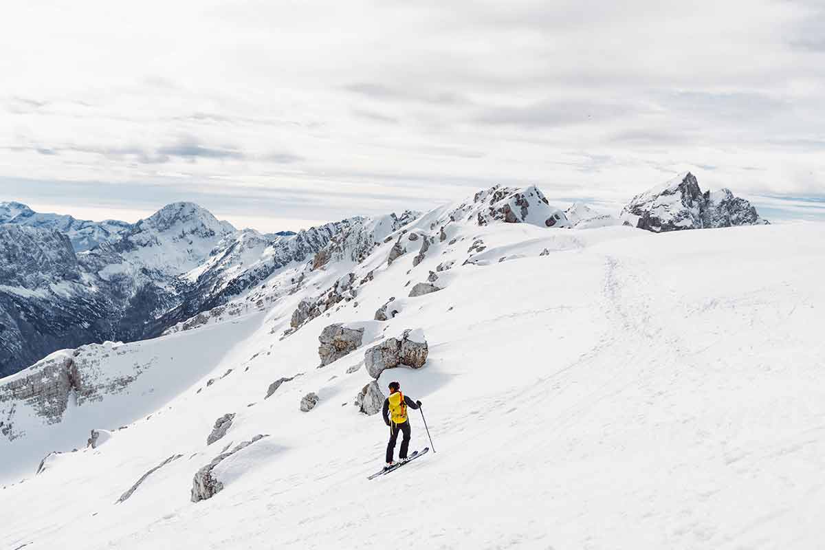 One Lonely Ski Tourer Skiing Down The Snowy Mountain