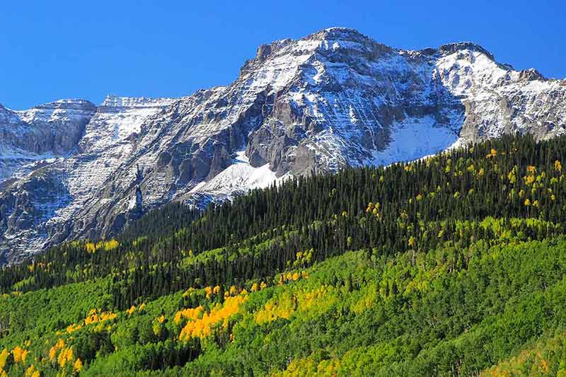 Mount Sneffels Range, Colorado, with snow-capped mountains and green trees