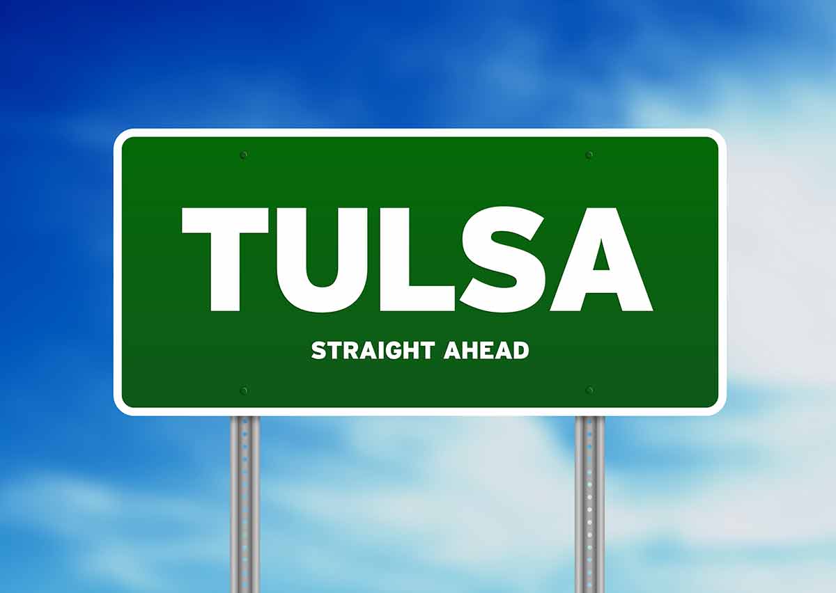 things to do in tulsa Green Tulsa, Oklahoma, USA highway sign on Cloud Background.