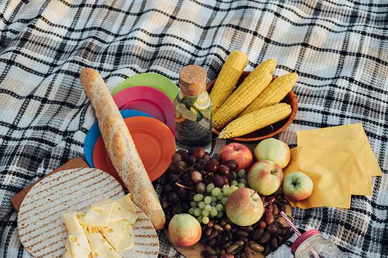 picnic food and fruit on a rug