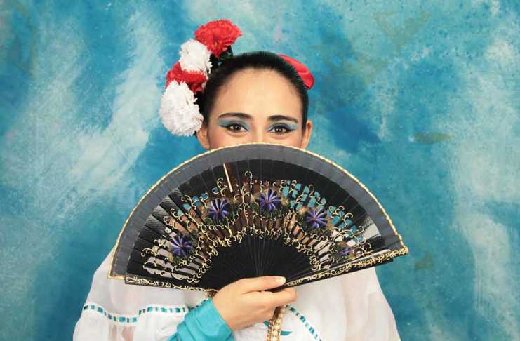 things to do in veracruz local with fan covering her face and flowers in her hair