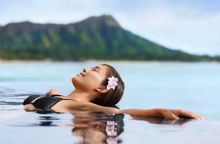 things to do in waikiki hawaii Hawaii vacation wellness pool spa woman relaxing in warm water at luxury hotel resort.
