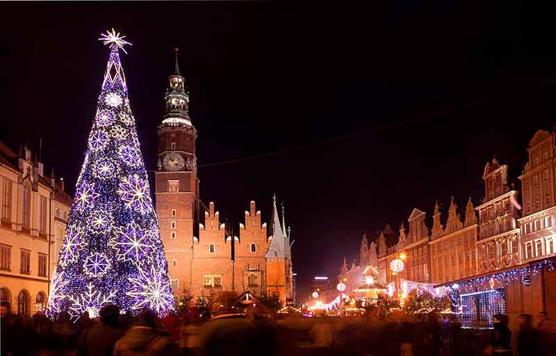 Christmas market in Wroclaw, Poland at night with a large purple Christmas tree