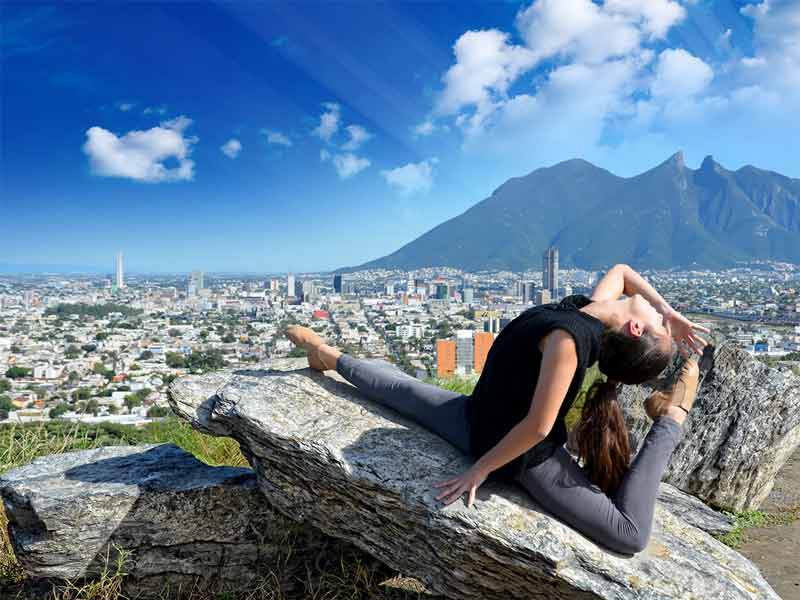 ballet dancer posing on a rock with Monterrey and mountains in the background