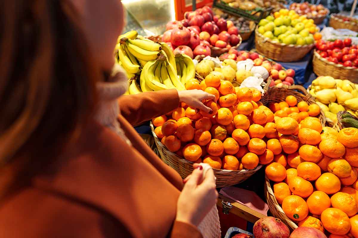 woman choosing oranges at a farmer's market