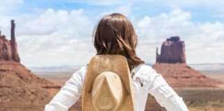 things to see and do in monument valley young woman wearing straw hat in Monument Valley.