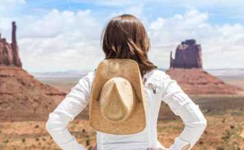 things to see and do in monument valley young woman wearing straw hat in Monument Valley.