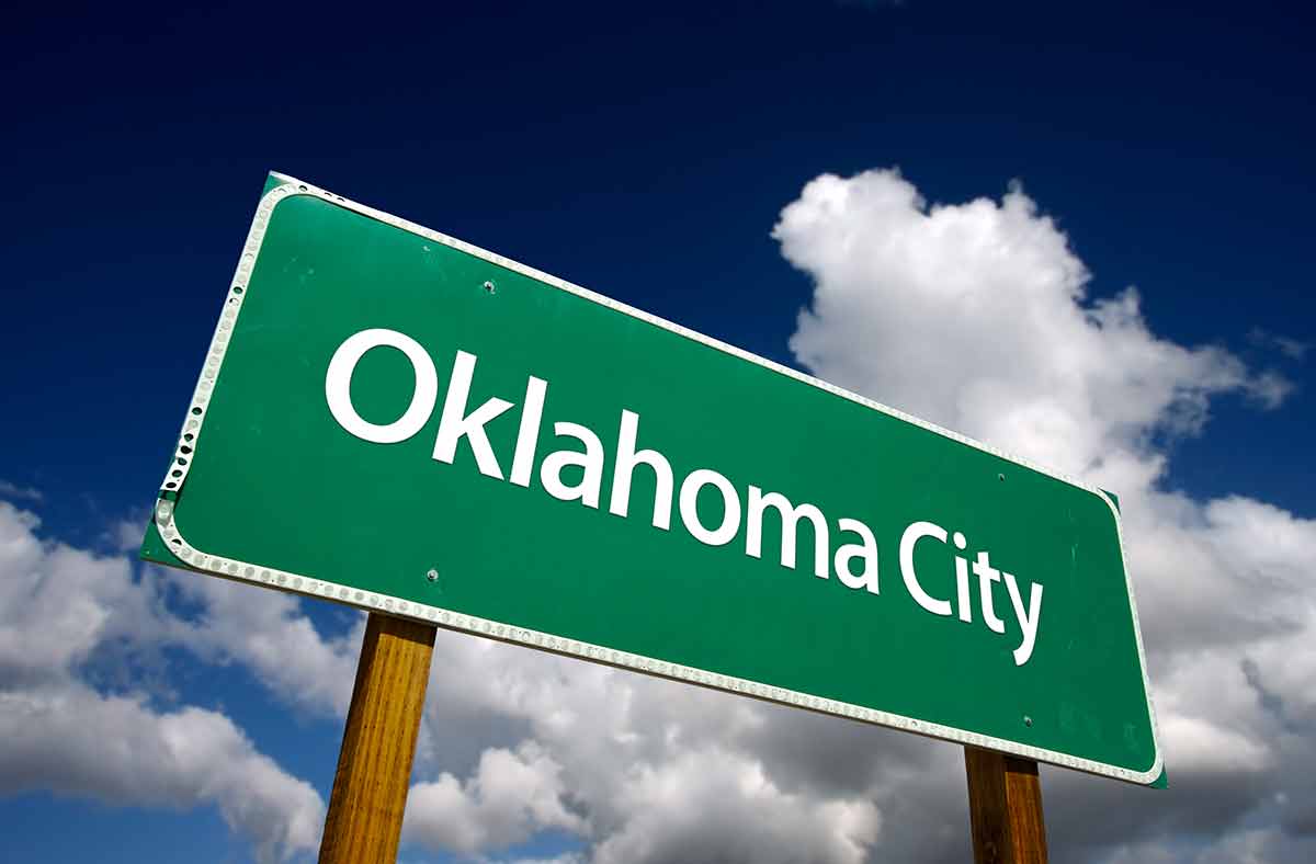 top 10 things to do in oklahoma city Road Sign with dramatic blue sky and clouds.