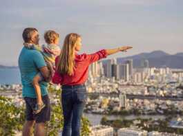 Happy family tourists on the background of Nha Trang city. Travel to Vietnam with kids.