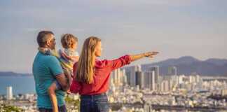 Happy family tourists on the background of Nha Trang city. Travel to Vietnam with kids.