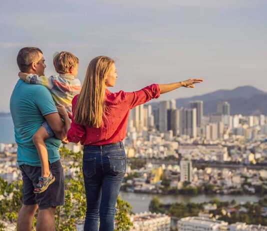 Happy family tourists on the background of Nha Trang city. Travel to Vietnam with kids.