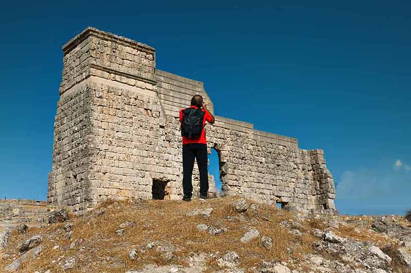 Man Photographing The Roman Ruins Of Acinipo
