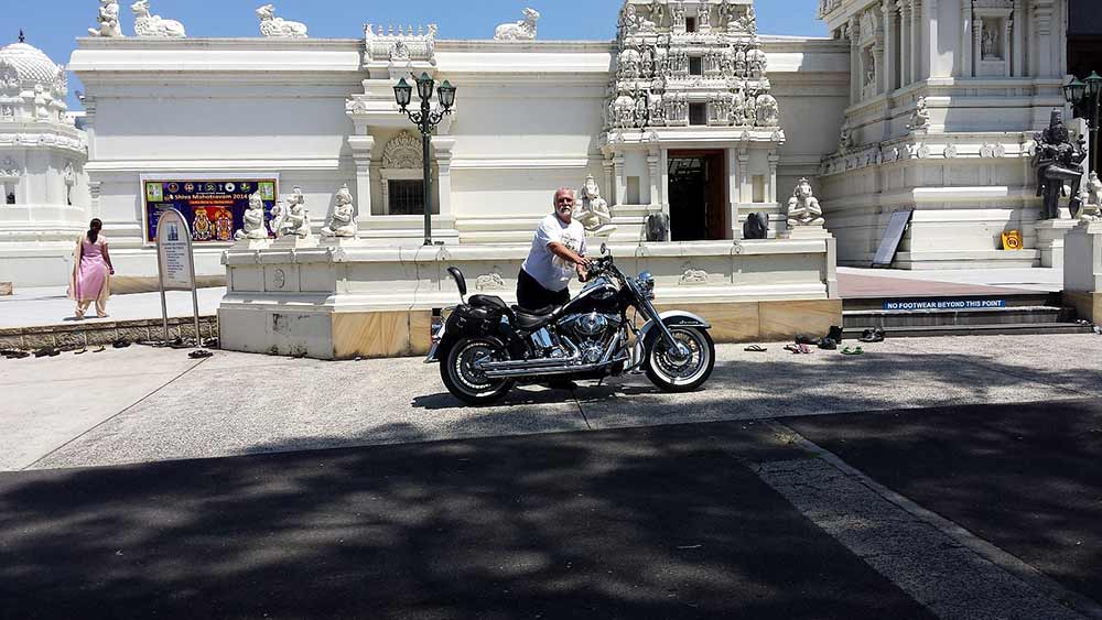 touring on a motorcycle in front of a Hindu temple