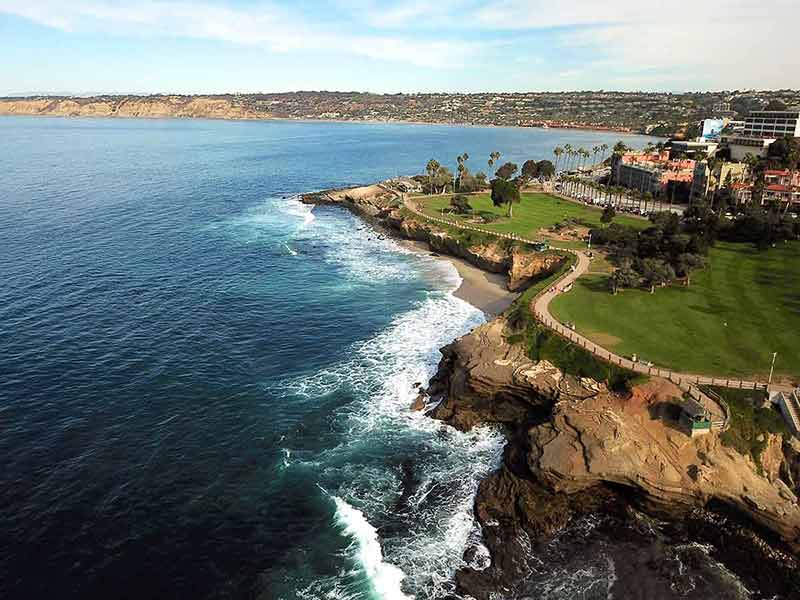 train from san diego to san francisco An aerial view of La Jolla Cove, a small picturesque cove and beach surrounded by cliffs