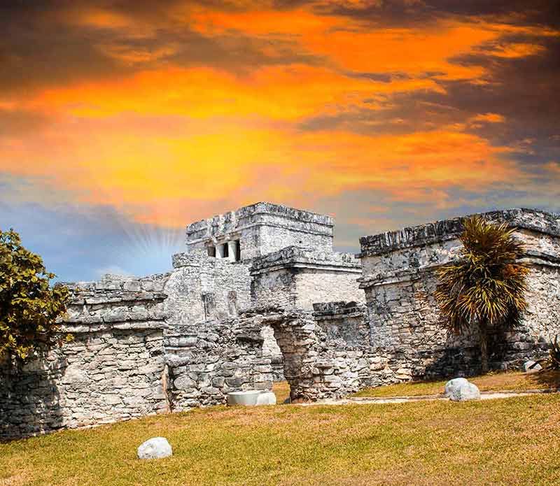 tulum mayan ruins against orange sky